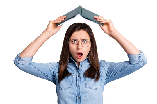 Close up photo of impressed sad girl hold open book above head open mouth wear spectacles blue cloth isolated on grey background