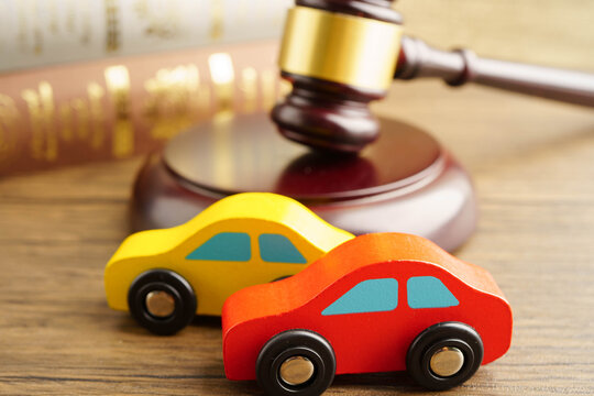 Car accident lawsuit and insurance, Judge hammer with car model.