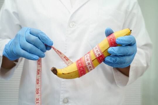 Doctor holding a banana with measuring tape, penis health.