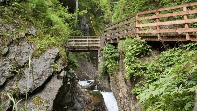 Wooden walkways crossing a rocky gorge above a flowing mountain stream in Bavaria, Germany