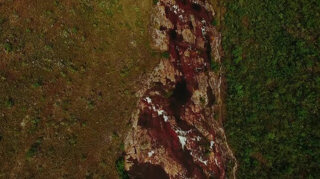 Dramatic aerial orbital view showing the rocky riverbed and cascades of the Couros Waterfalls in the Chapada dos Veadeiros National Park