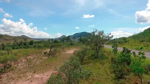 Aerial view flying forward over a rural road near the Morro da Baleia in the Chapada dos Veadeiros National Park, Brazil