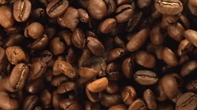 Roasted coffee beans falling in super slow motion macro top view