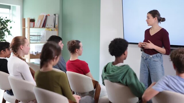 During talk in at class, teen pupil listen to lecture. Discussions on career guidance, representative of educational institution to conduct introductory lecture for applicants 