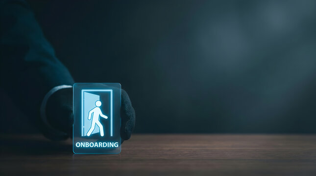 A hand in a black glove places a digital onboarding icon on a wooden desk