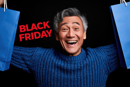 Excited Asian man clutching blue shopping bags, radiating joy and anticipation on Black Friday, capturing the thrill of a great deal.