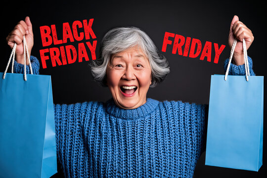 An excited elderly Asian woman is holding blue shopping bags and smiling while celebrating Black Friday with the text BLACK FRIDAY on the background.