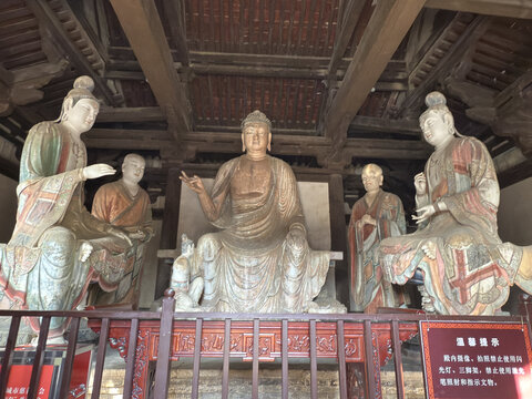Ancient Buddhist temple interior with seated Buddha and attendant statues