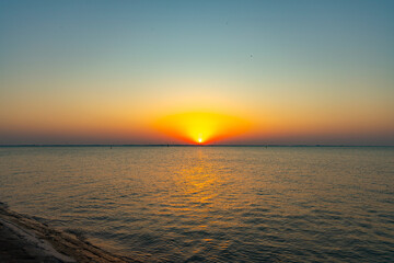 Obraz premium Golden Sunset Over Calm Sea