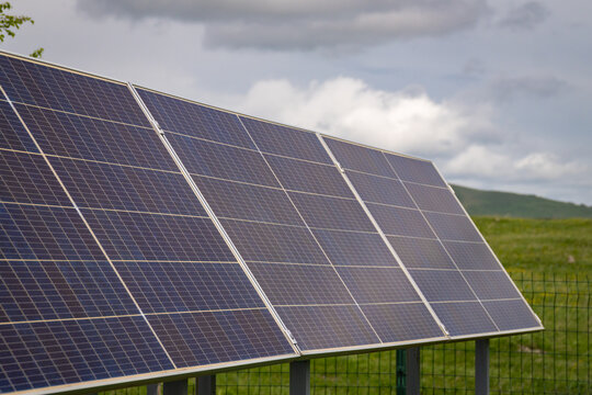 Solar panels are collecting sunlight, converting it into clean, sustainable energy, contributing to ecological balance and reducing environmental impact in a natural, green outdoor setting