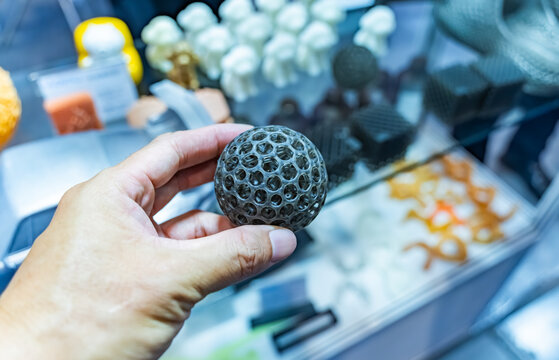 hand with flexible object printed on 3d printer close-up