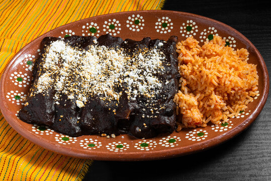 Traditional Mexican Enchiladas With Mole Sauce and Rice on Talavera Plate