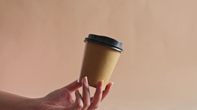 Hand presenting biodegradable paper coffee cup with black lid For Eco-friendly lifestyle concept