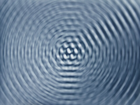 Abstract blue water ripples creating concentric circular wave patterns