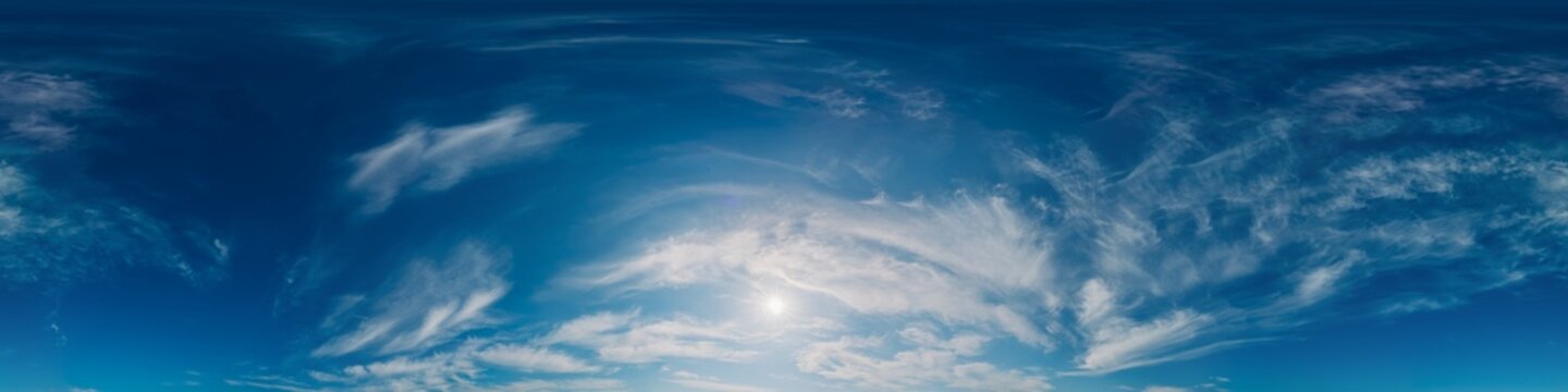 Sky clouds sun clear blue vista with wispy cirrus patterns and bright sunlight in an equirectangular projection