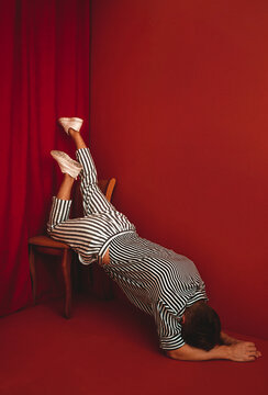 Person in striped clothing expressing depression and burnout indoors