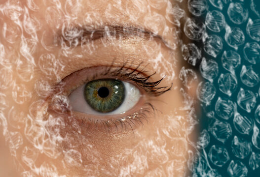 Woman looking through plastic film highlighting environmental pollution