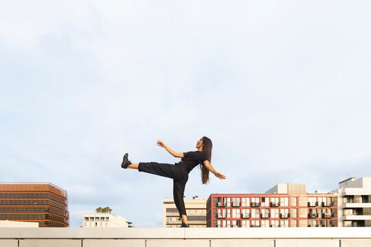 Woman dances on a platform against the city skyline in Barcelona