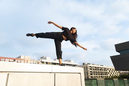 A confident woman dances on an outdoor platform in Barcelona