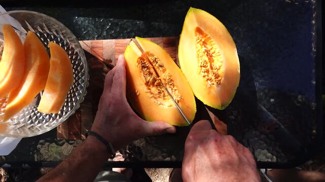 Solomons, Maryland USA An orange and ripe Cantaloupe melon is sliced into a bowl. 