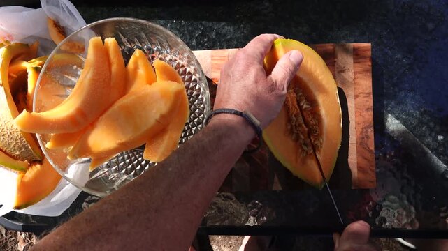 Solomons, Maryland USA An orange and ripe Cantaloupe melon is sliced into a bowl. 