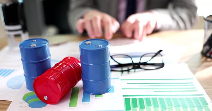 In a lively office setting, hands are seen typing as vibrant blue and red containers sit atop colorful graphs and charts, sparking ideas and collaboration among colleagues.
