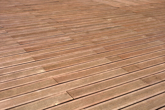 Dark brown composite wooden deck flooring planks.