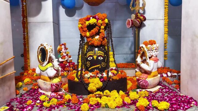 A sacred black Shivalinga beautifully decorated with marigold flowers and traditional offerings inside a Hindu temple, symbolizing devotion and reverence for Lord Shiva.