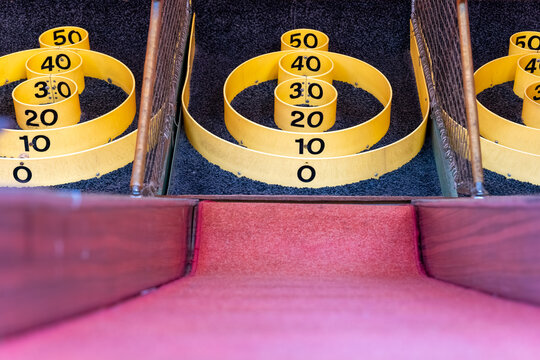 Skee ball game setup with numbered rings at an amusement arcade