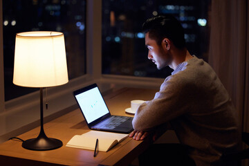 Fototapeta premium Man Working Late on Laptop at Desk at Night