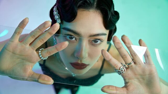 Moving clear panel, model with rhinestone clip, rings framing face in studio, making highlights