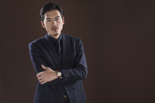 Confident businessman in pinstripe suit, arms crossed
