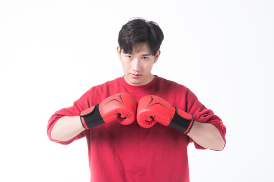 Young Asian man with boxing gloves in fighting pose