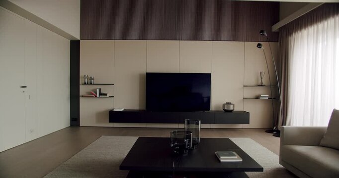 A sleek minimalist living room featuring a large flat-screen TV, stylish furniture, and soft lighting, evoking a serene atmosphere. Modern Minimalist Living Room Interior with Comfortable Design