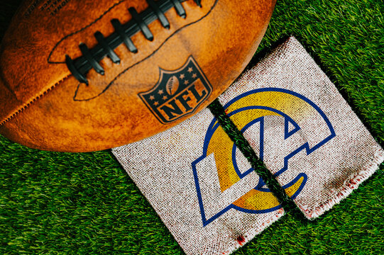 Los Angeles Rams team logo printed on rustic jute fabric next to an official NFL leather football on green turf.