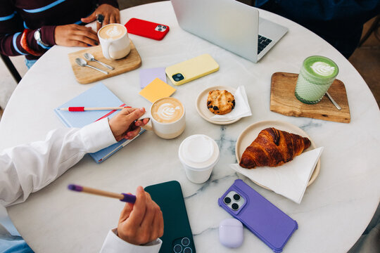 Colleagues meeting at cafe with laptops and coffee