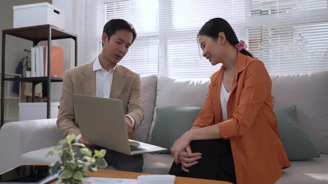 Asian female financial advisor using smartphone for personal wealth planning and investment research modern home office, professional attire, focused expression, elegant living room interior