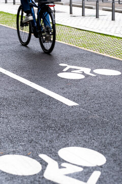 Cyclist using a marked bike lane with bicycle symbols on an urban street in Lyon France where everyday mobility and transport share public space