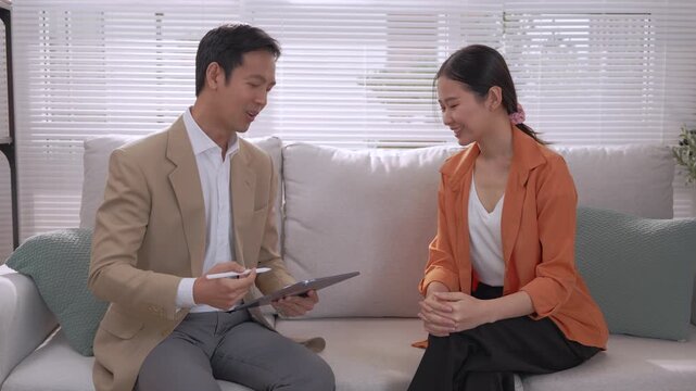 Financial advisor discussing wealth planning with Asian client during professional consultation and thoughtful meeting, reviewing tablet, offering attentive guidance, building trust through calm