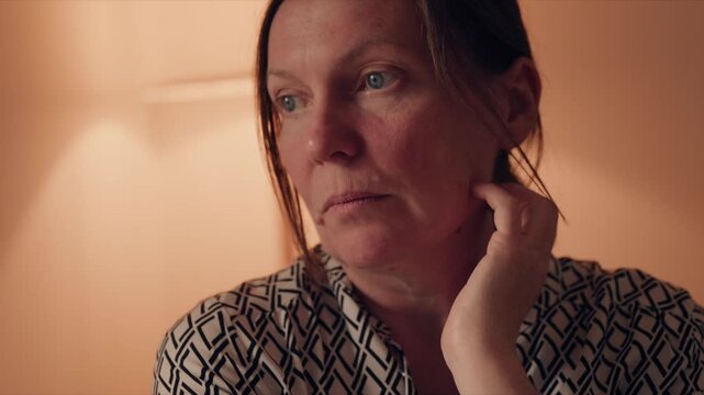 Mature woman sitting at home with anxious expression, stress and emotional concern concept, 4K
