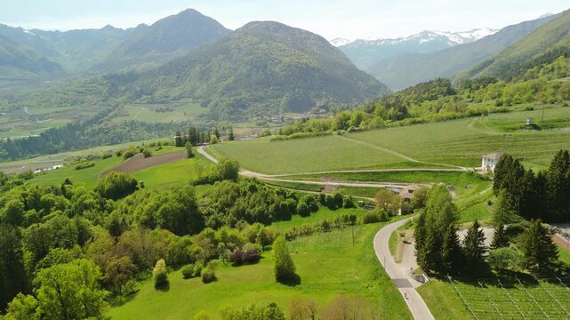 Aerial drone perspective of rolling green hills, lush mountain valleys, and rural countryside in Premione, Trento, Italy. Scenic regional landscape.