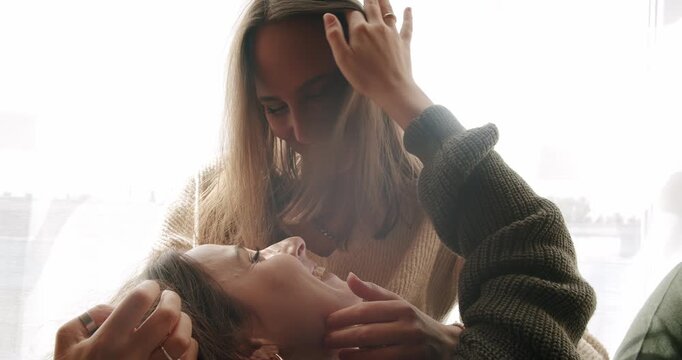 Couple of women hug each other warmly and relax at home in the bedroom. Close up look at face. look in the eyes in love. lgbt and lesbian women at home. LGBT rights, Lesbian family.