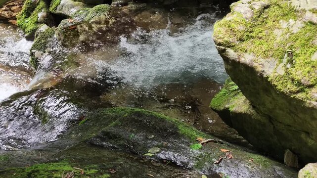 Close up of white water splashing over rocks at Hossawa Falls Japan