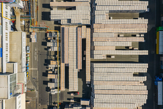 Aerial view of a logistics warehouse with rows of stacked pallets and industrial infrastructure in the yard in Kyjov, South Moravian Region, Czechia.