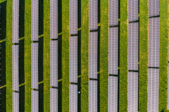 Aerial view of rows of solar panels arranged in a green field in Kyjov, South Moravian Region, Czechia.