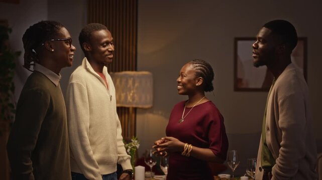 Young adult African American friends doing fist bump greeting while gathering for holiday dinner celebration. Footage suited for Thanksgiving advertising and friendship campaigns