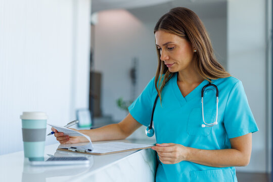 Healthcare professional reviewing medical records at clinic reception