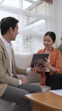 Financial Advisor Wealth Planning Consultation With Asian Woman Reviewing Financial Document And Laptop During Professional Discussion, Concerned Focused Expression In Modern Office Setting