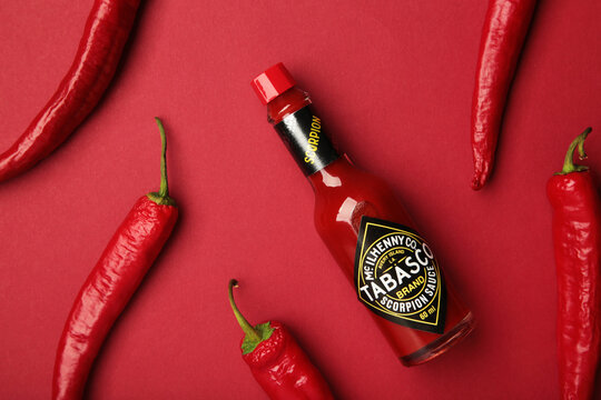 Mykolaiv, Ukraine - August 19, 2026: A bottle of Tabasco pepper sauce with red chili pepper on red background