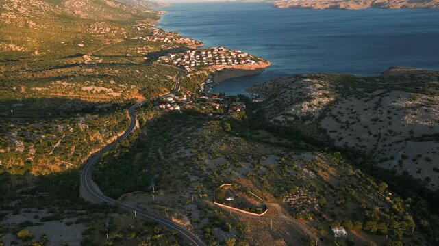 Winding coastal road leading at sunset to Cesarica village in Croatia